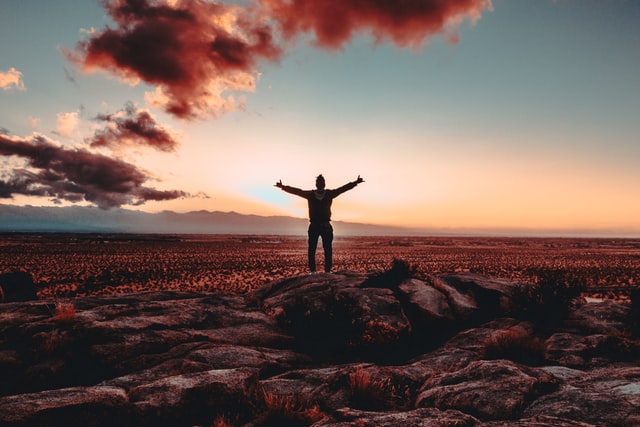 On the image, there is a person who is stretching his arms like he can take on the world. He looks successful and happy.