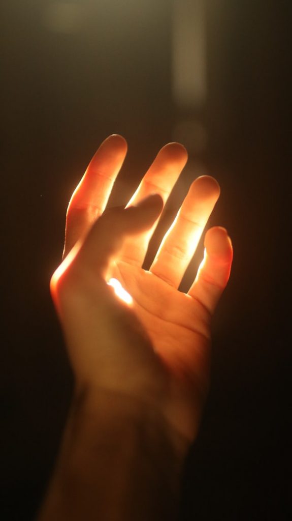 This image visualizes how a highly sensitive person is privileged when it comes to their trait and the use of the law of attraction. There is a hand with light shining on it, looking like it is ready to receive.