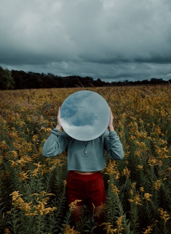How does visualization work? In this image, a woman is holding a mirror in front of her face, perfectly visualizing what visualization may look like.